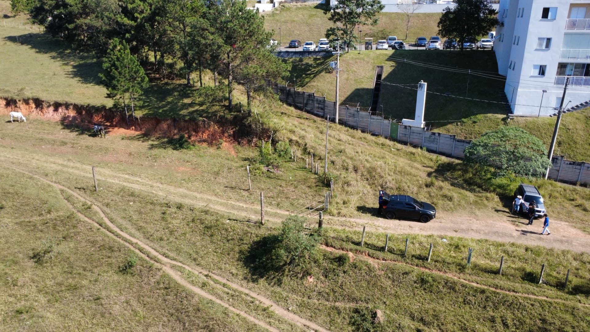 Imagem aérea de drone sobre terreno e perímetro murado